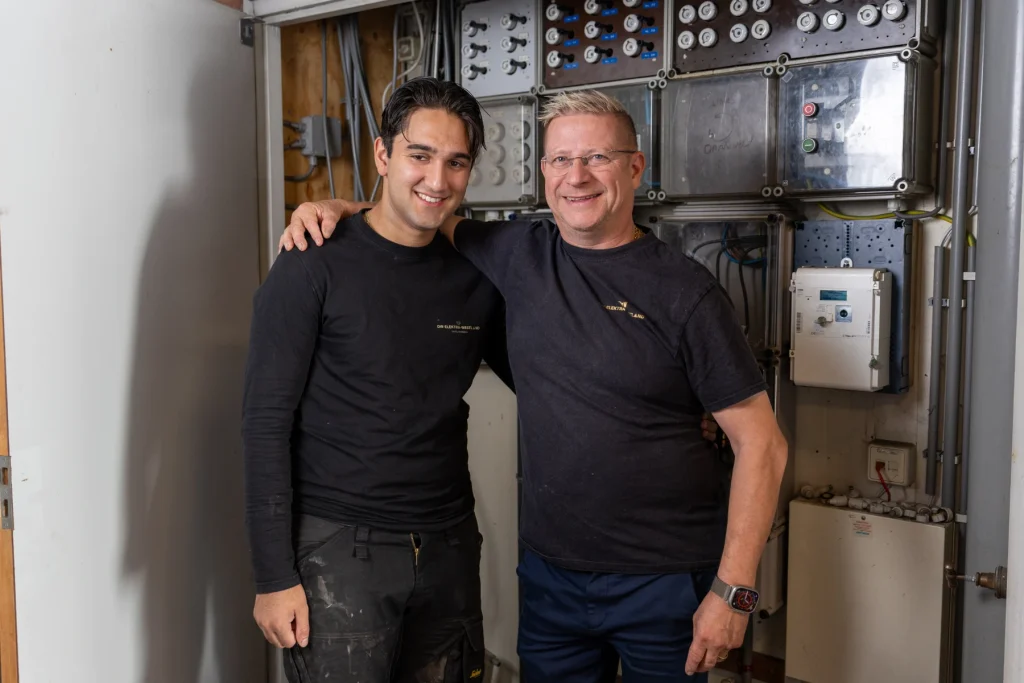 Vader en zoon Wierenga samen in een ruimte met elektrische installaties